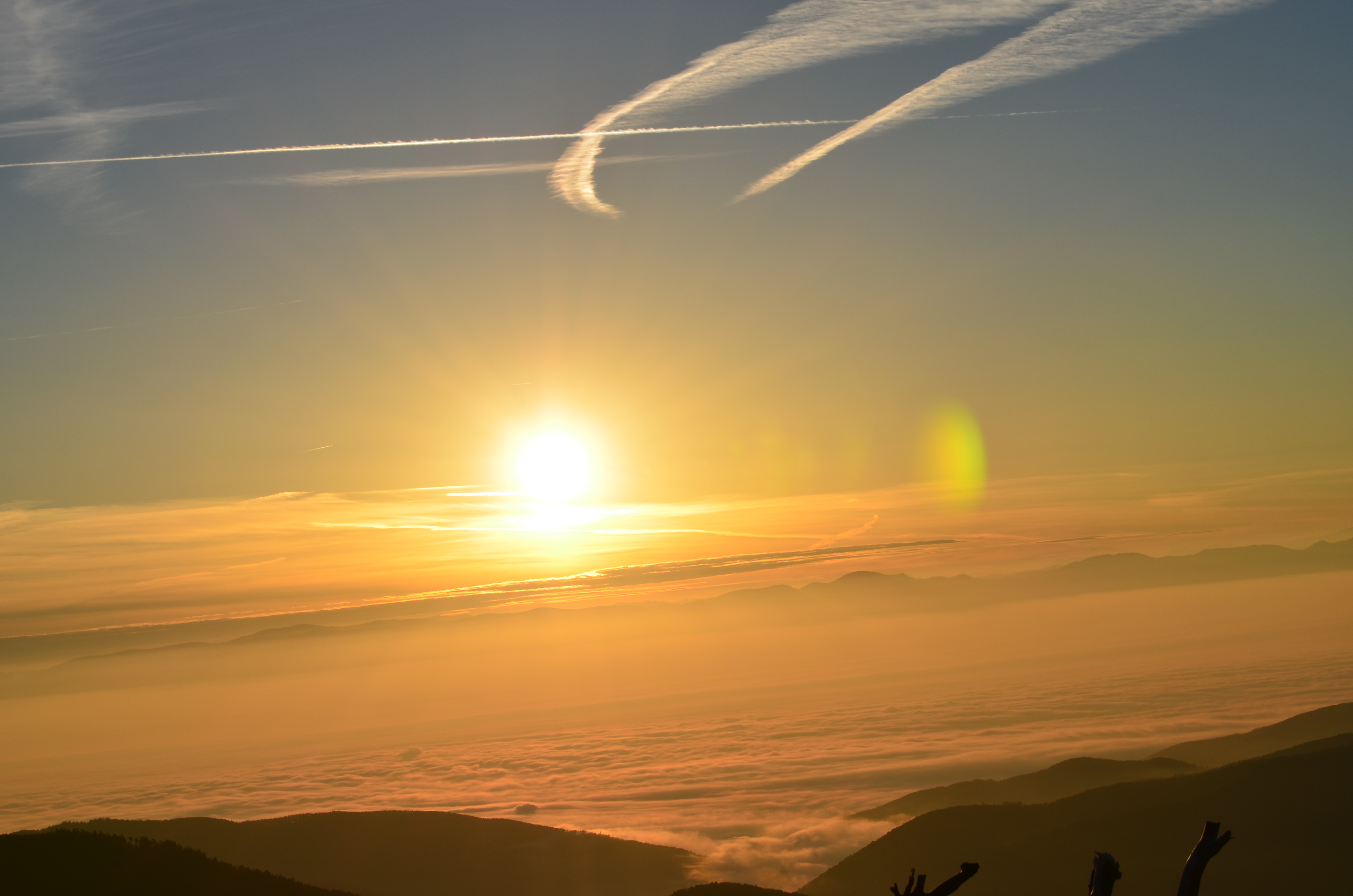 Sunrise over Brezouard mountain landscape with golden and orange hues illuminating the peak and surrounding valley, creating a serene and inspiring atmosphere